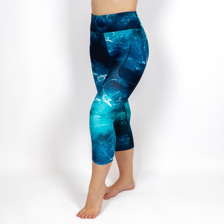 Kvinde i højtaljede mønstrede capris. Capris har lommer på begge sider. Meget elastiske og squat proof.
