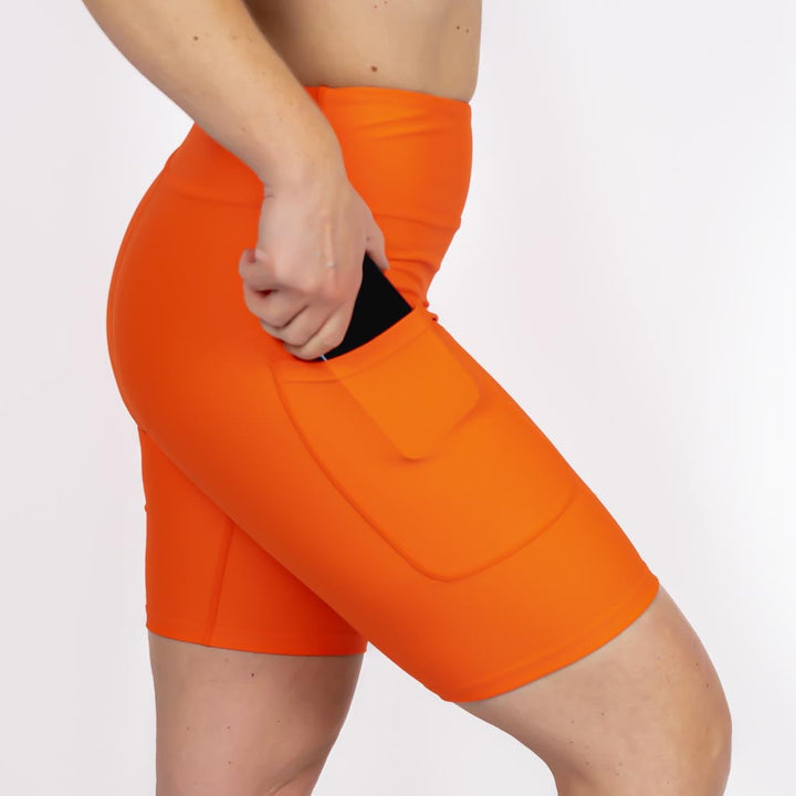 Kvinde i højtaljede ensfarvet shorts. Shorts har lommer på begge sider. Meget elastiske og squat proof.
