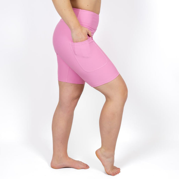 Kvinde i højtaljede ensfarvet capris. Capris har lommer på begge sider. Meget elastiske og squat proof.