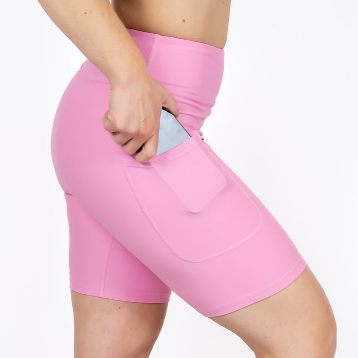 Kvinde i højtaljede ensfarvet capris. Capris har lommer på begge sider. Meget elastiske og squat proof.