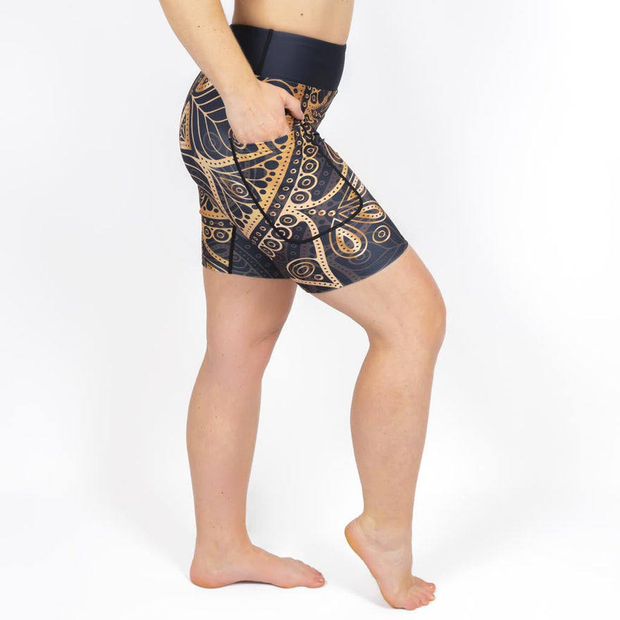 Kvinde i højtaljede mønstrede shorts. Shorts har lommer på begge sider. Meget elastiske og squat proof.