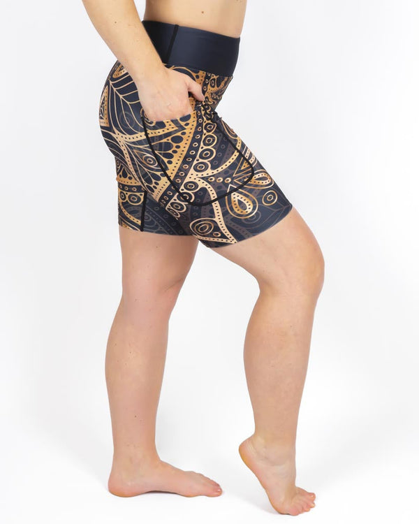 Kvinde i højtaljede mønstrede shorts. Shorts har lommer på begge sider. Meget elastiske og squat proof.